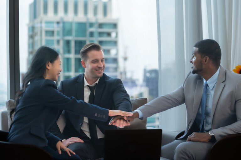 Business professionals in a meeting shaking hands, symbolizing trust and strategic partnerships in government contracting.